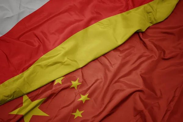 挥舞着五颜六色的中国国旗和南奥塞梯国旗. — 图库照片