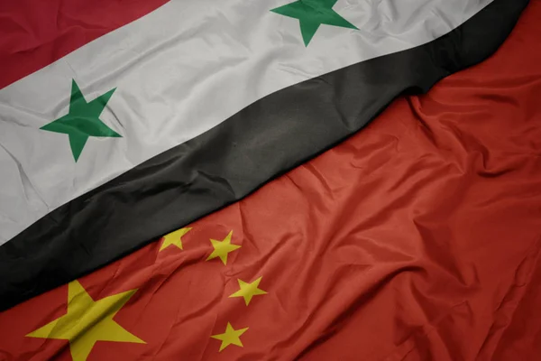 Sventolando bandiera colorata della Cina e bandiera nazionale della Siria . — Foto Stock