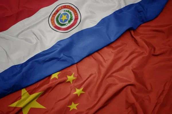 Махаючи барвистий прапор Китаю і національний прапор Парагваю . — стокове фото