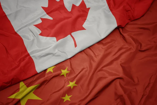 Mávající barvitá vlajka Číny a národní vlajka Kanady. — Stock fotografie