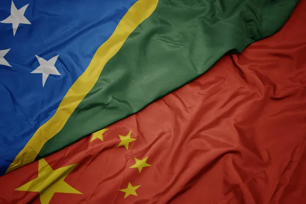 Waving colorful flag of china and national flag of Solomon Islands. — Stock Photo, Image