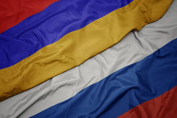 Agitant drapeau coloré de la Russie et drapeau national de l'arménie . — Photo