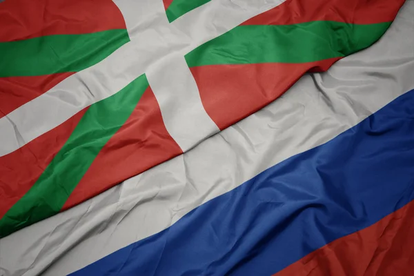 Waving colorful flag of russia and national flag of basque country. — Stock Photo, Image