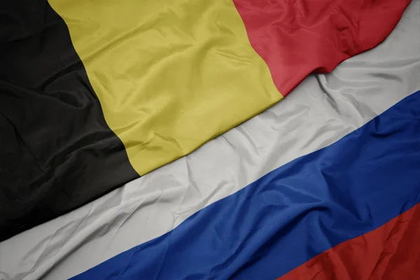 Ondeando colorida bandera de Rusia y bandera nacional de Bélgica . —  Fotos de Stock