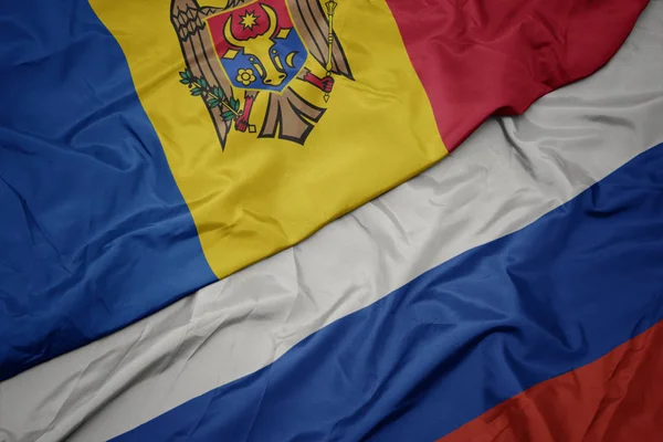 Ondeando colorida bandera de Rusia y bandera nacional de Moldavia . —  Fotos de Stock