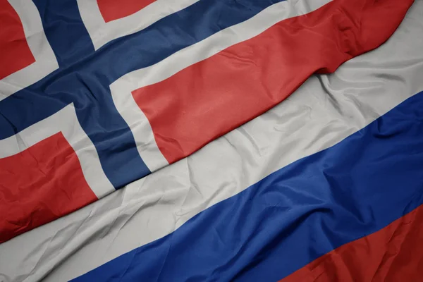 Schwenken bunte Flagge Russlands und Nationalflagge Norwegens. — Stockfoto