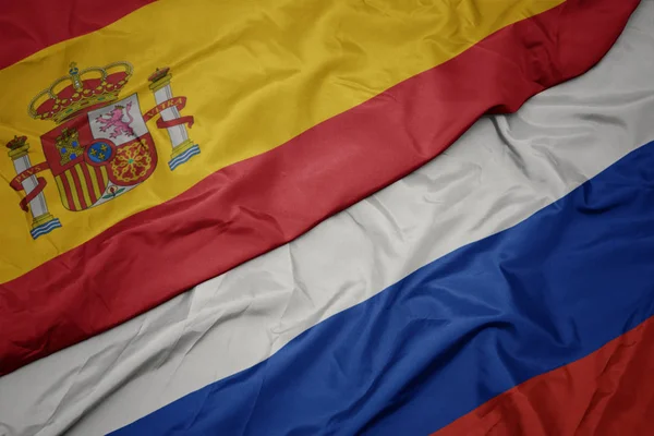 Размахивая красочным флагом России и национальным флагом Испании . — стоковое фото