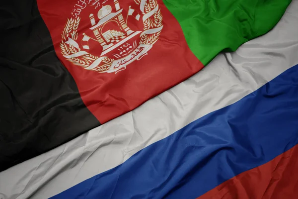 Ondeando colorida bandera de Rusia y bandera nacional de Afganistán . — Foto de Stock