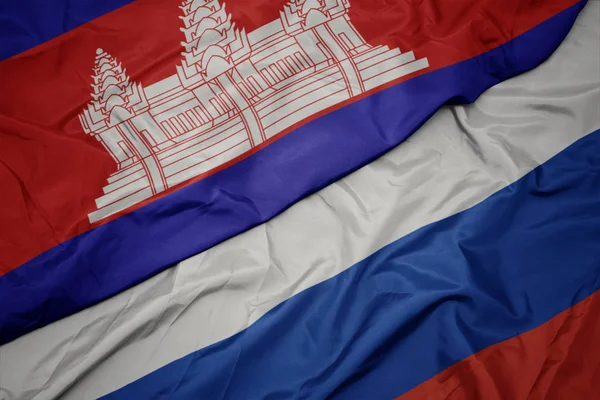 Ondeando colorida bandera de Rusia y bandera nacional de Camboya . —  Fotos de Stock