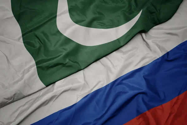 Waving colorful flag of russia and national flag of pakistan. — Stock Photo, Image