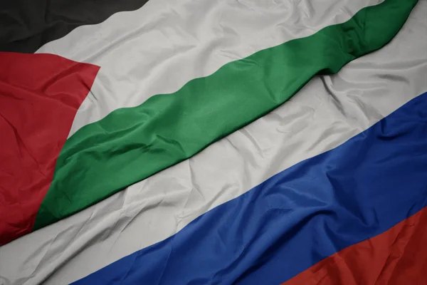 Waving colorful flag of russia and national flag of palestine. — Stock Photo, Image
