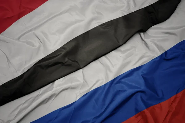 Розмахуючи барвистим прапором Росії та національним прапором Ємену. — стокове фото