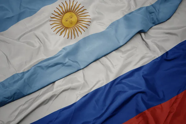 Acenando bandeira colorida da Rússia e bandeira nacional da argentina . — Fotografia de Stock