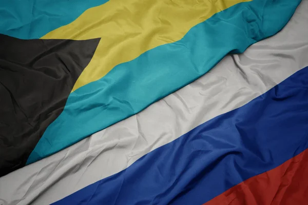 Waving colorful flag of russia and national flag of bahamas. — Stock Photo, Image