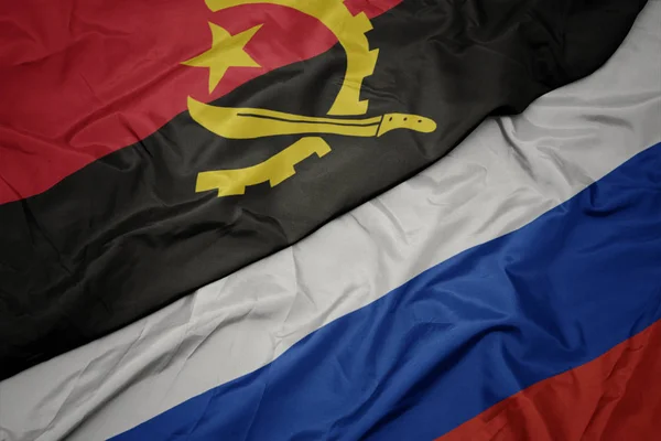Розмахуючи барвистий прапор Росії і Національний прапор Ангола. — стокове фото