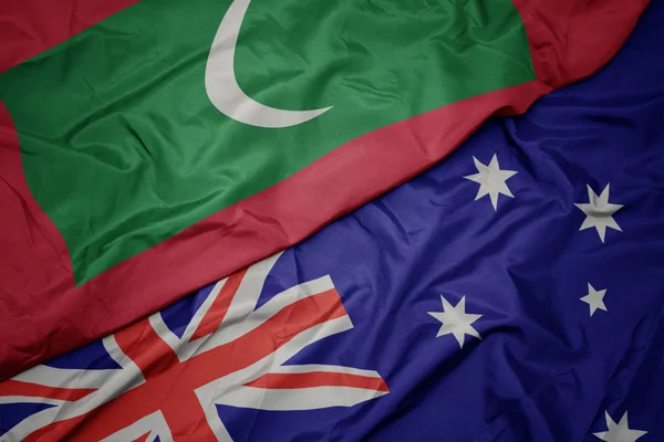 オーストラリアのカラフルな旗とモルディブの国旗を振る. — ストック写真