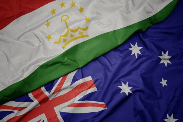 オーストラリアのカラフルな旗とタジキスタンの国旗を振る. — ストック写真