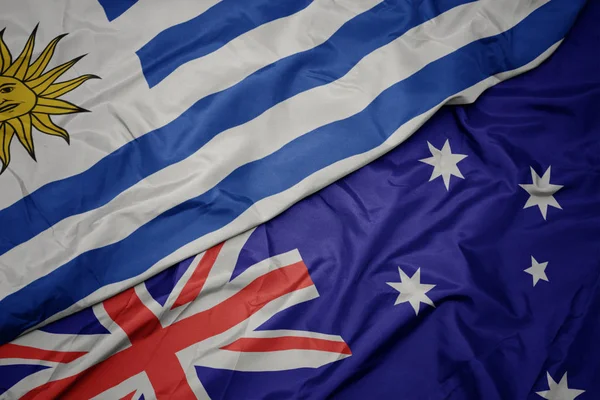 Avustralya ve uruguay ulusal bayrağı renkli bayrak sallayarak.