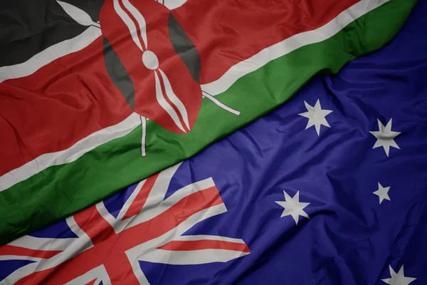 Agitant le drapeau coloré de l'Australie et le drapeau national du Kenya . — Photo
