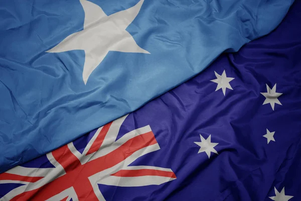 Hullámzó Ausztrália és Szomália nemzeti zászlaja. — Stock Fotó