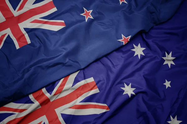 Ondeando colorida bandera de Australia y bandera nacional de Nueva Zelanda . — Foto de Stock