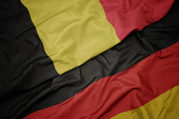 Agitant le drapeau coloré de l'Allemagne et le drapeau national de la Belgique . — Photo