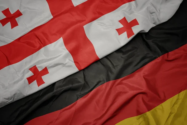 Размахивая красочным флагом Германии и национальным флагом Джорджии . — стоковое фото