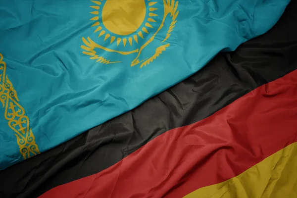 Almanya ve kazakistan ulusal bayrağı renkli bayrak sallayarak. — Stok fotoğraf