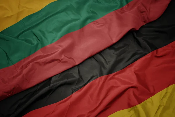 Acenando bandeira colorida da alemanha e bandeira nacional da lituânia . — Fotografia de Stock
