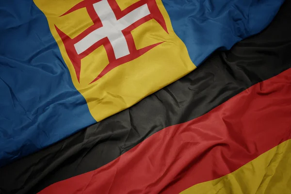 Ondeando colorida bandera de Alemania y bandera nacional de Madeira . —  Fotos de Stock