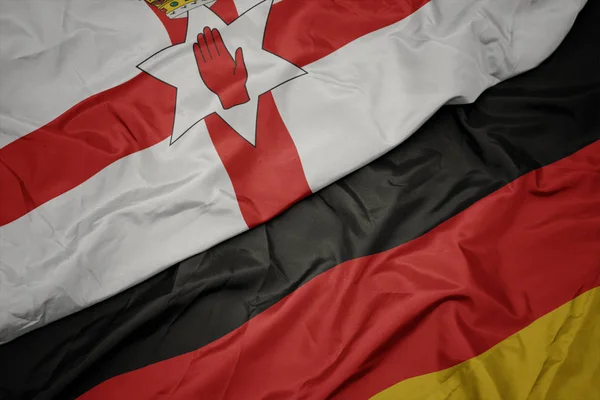 Waving colorful flag of germany and national flag of northern ireland. — Stock Photo, Image