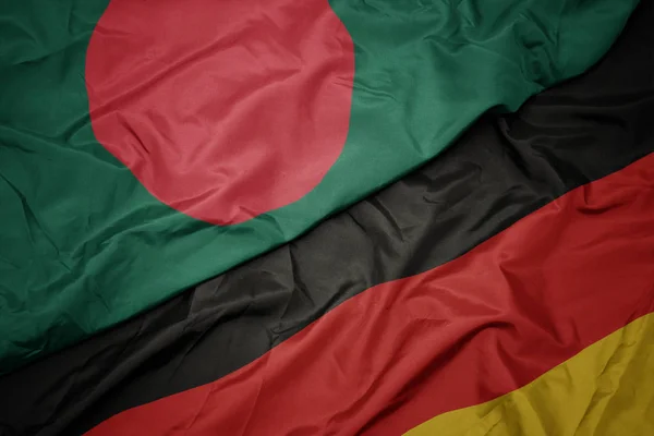 Agitant drapeau coloré de l'Allemagne et drapeau national du bangladesh . — Photo