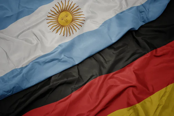 Waving colorful flag of germany and national flag of argentina. — Stock Photo, Image