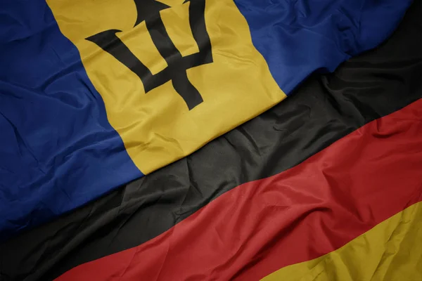 Acenando bandeira colorida da alemanha e bandeira nacional de barbados . — Fotografia de Stock