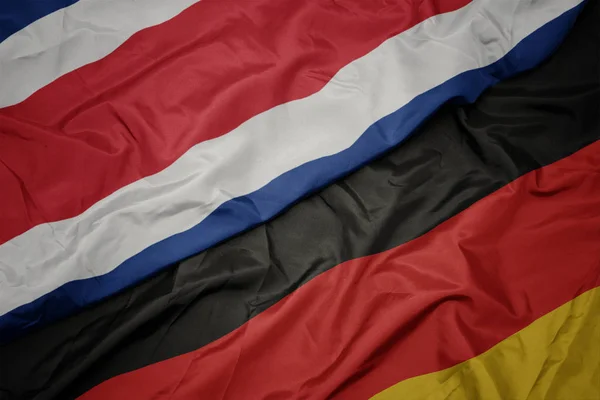 Acenando bandeira colorida da alemanha e bandeira nacional da costa rica . — Fotografia de Stock