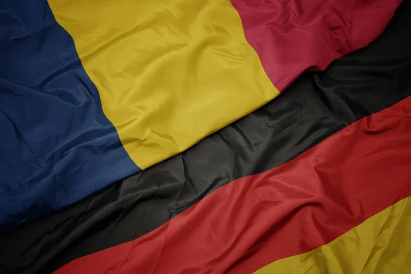 Ondeando bandera colorida de Alemania y bandera nacional de Chad . —  Fotos de Stock