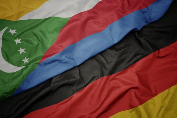 Waving colorful flag of germany and national flag of comoros. — Stock Photo, Image