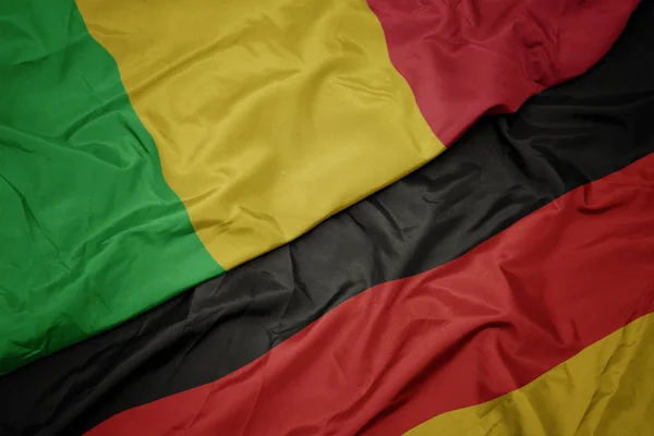Acenando bandeira colorida da alemanha e bandeira nacional do mali . — Fotografia de Stock
