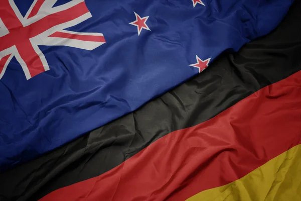 Waving colorful flag of germany and national flag of new zealand. — Stock Photo, Image