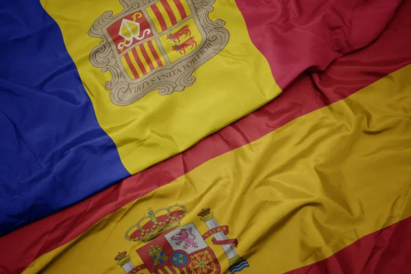 Agitant drapeau coloré de l'Espagne et drapeau national de l'andorre . — Photo