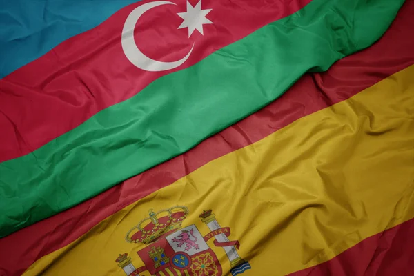 Agitant drapeau coloré de l'Espagne et drapeau national de azerbaijan . — Photo