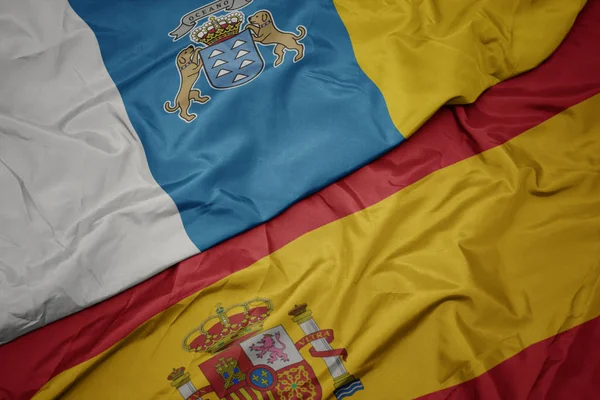 Agitant drapeau coloré de l'Espagne et drapeau national des îles Canaries . — Photo