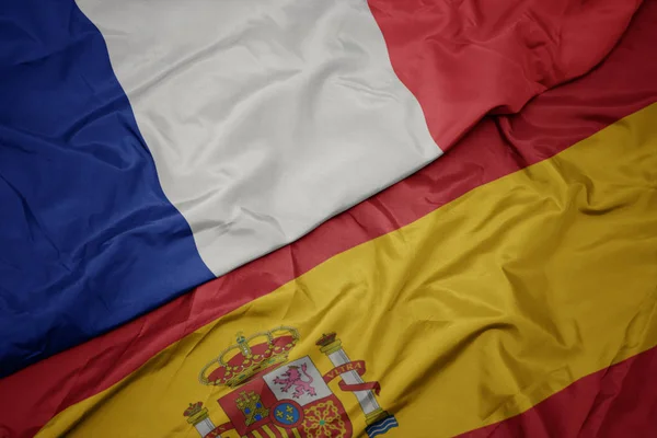 Waving colorful flag of spain and national flag of france. — Stock Photo, Image
