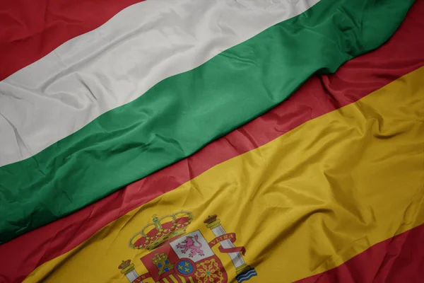 Размахивая красочным флагом Испании и национальным флагом Венгрии . — стоковое фото