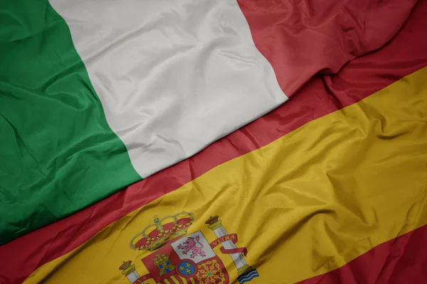 Ondeando colorida bandera de España y bandera nacional de Italia . —  Fotos de Stock