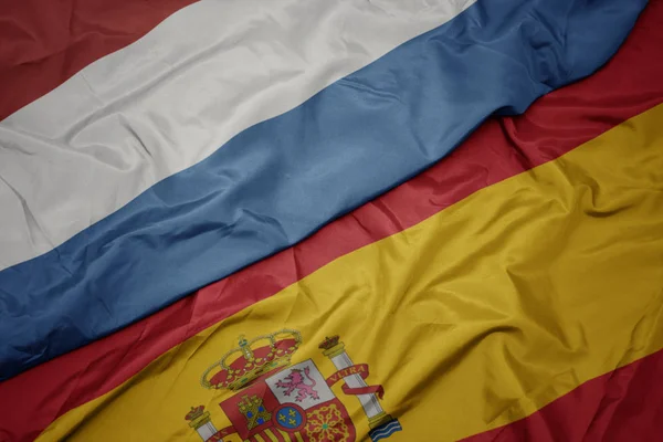 Waving colorful flag of spain and national flag of luxembourg. — Stock Photo, Image