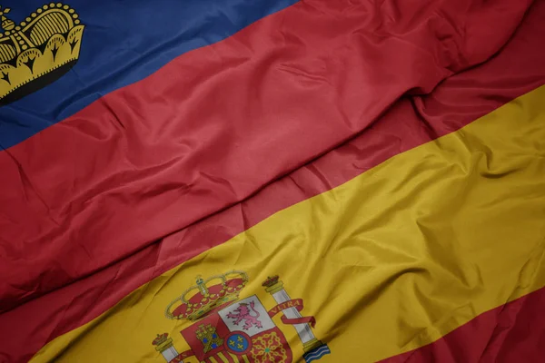 Размахивая красочным флагом Испании и национальным флагом Лихтенштейна . — стоковое фото