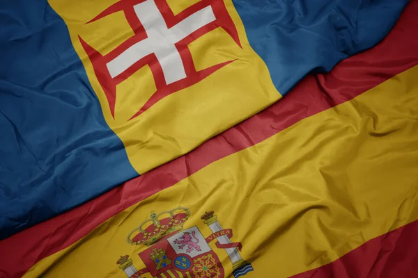 Vinka färgglada flagga av Spanien och nationella flagga Madeira. — Stockfoto