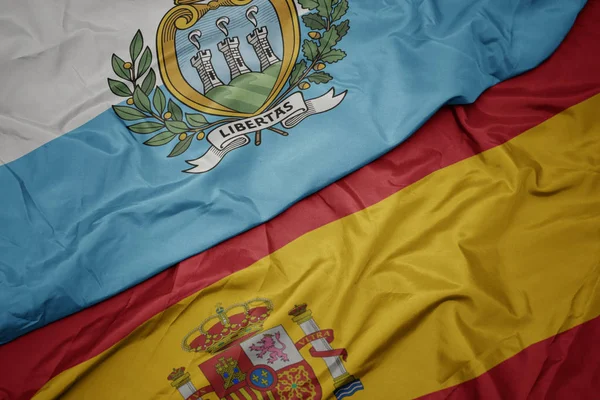 Agitant drapeau coloré de l'Espagne et drapeau national de san marino . — Photo