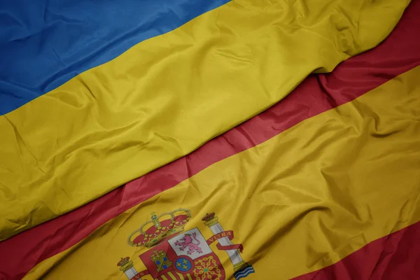 Размахивая красочным флагом Испании и национальным флагом Украины . — стоковое фото
